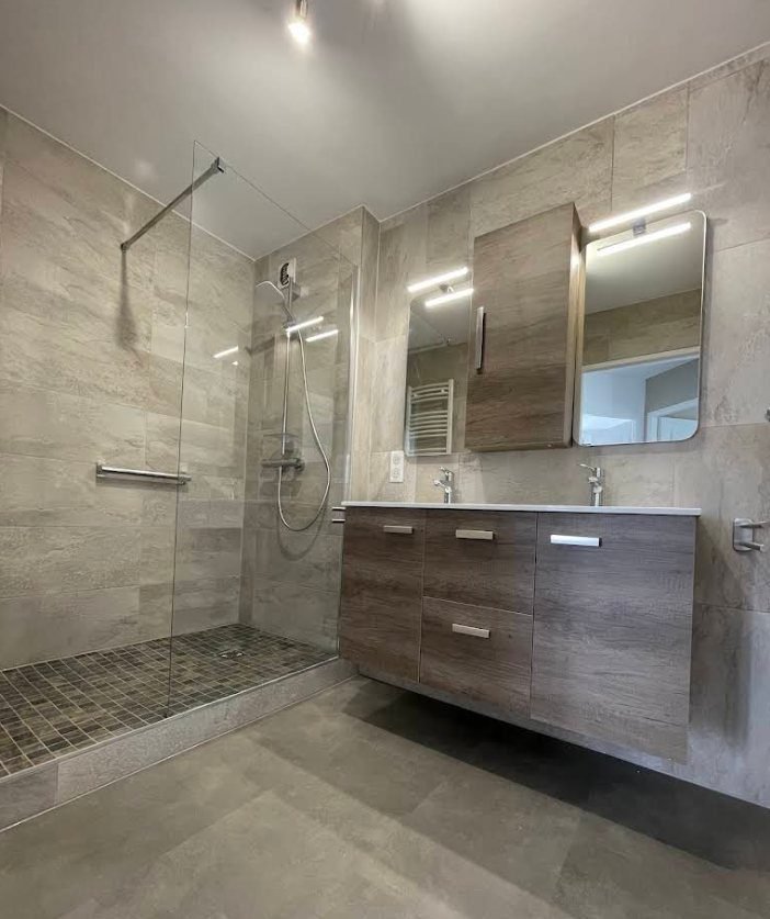 Salle de bain avec douche à l'italienne, double vasque et miroirs rétroéclairés